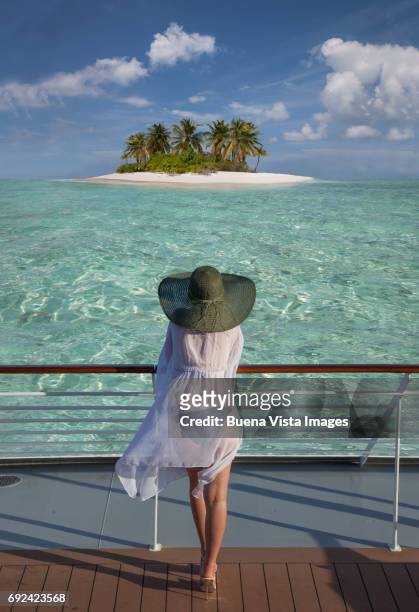 woman on a cruise ship watching a solitary island - schiffsdeck stock-fotos und bilder