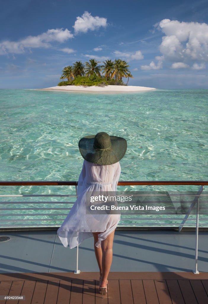 Woman on a cruise ship watching a solitary island