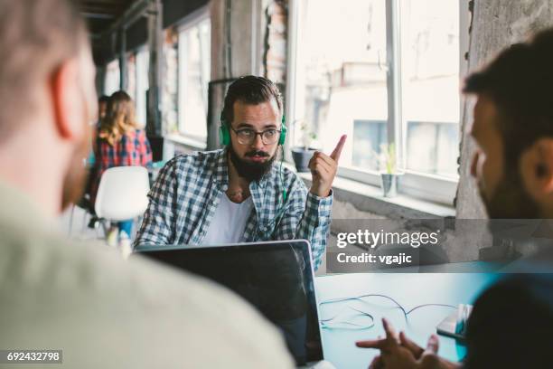 collega's samenwerken in het bureau - hand opsteken stockfoto's en -beelden