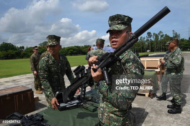 Philippine Marine holds an M60 machine gun during a handover ceremony of weapons from the US military, at Marine headquarters in Manila on June 5,...