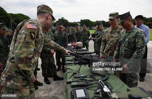 Philippine Marine Commandant Major General Emmanuel Salamat listens to US military representatives during a handover ceremony of weapons from the US...