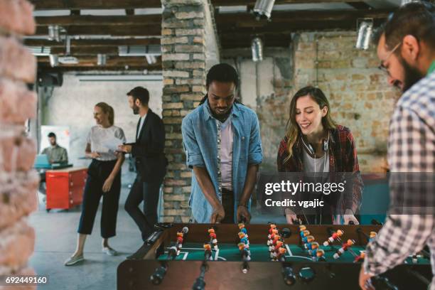 coworkers playing foosball - table football stock pictures, royalty-free photos & images