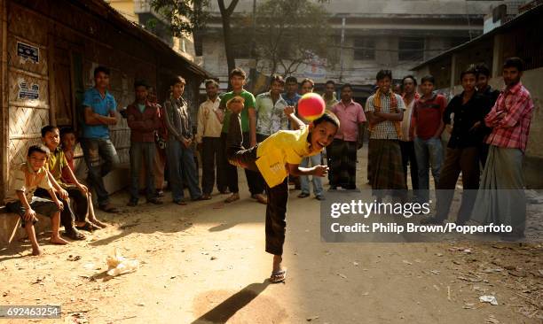 Boy bowling a ball in a street watched by a crowd of people in Chittagong. The ICC Cricket World Cup group B match between Bangladesh and England...