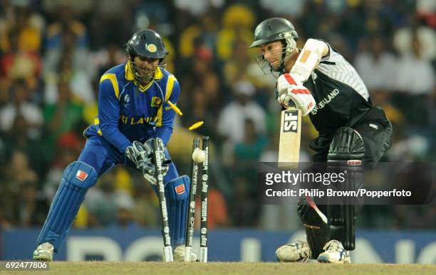 New Zealand's Andy McKay is bowled by Sri Lanka's Ajantha Mendis as Sri Lanka's captain and wicketkeeper Kumar Sangakkara looks on during their ICC...