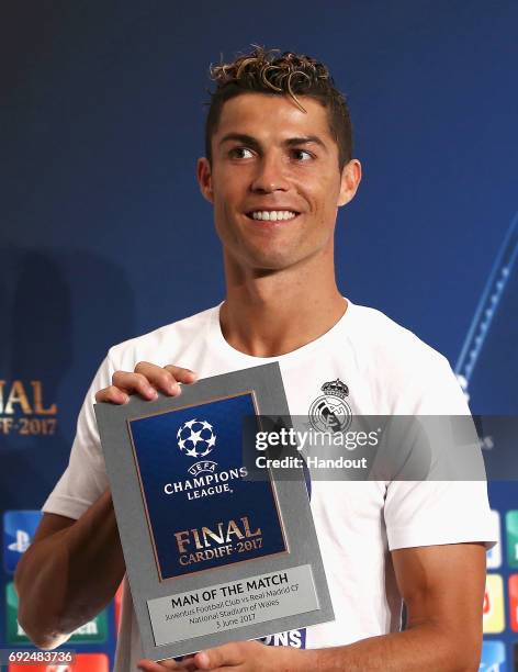 In this handout image provided by UEFA, Cristiano Ronaldo of Real Madrid poses with the Man of the Match award after the UEFA Champions League Final...