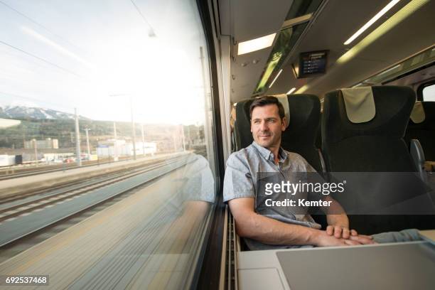 affärsman som tittar ut fönstret under resor med tåg - front view bildbanksfoton och bilder