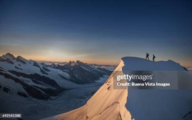 climbers reaching the top of a mountain - leistung stock-fotos und bilder