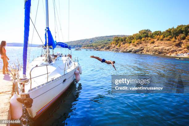 coppia che si gode la vela in yacht - jumping of boat foto e immagini stock