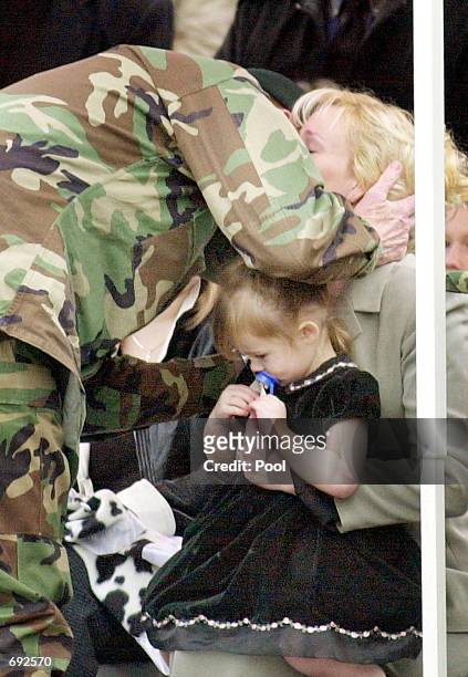 Maj. Gen. Geoffrey C. Lambert leans down to embrace Renae Chapman as her daughter Amanda, two, sits on her lap at a memorial service for her husband,...