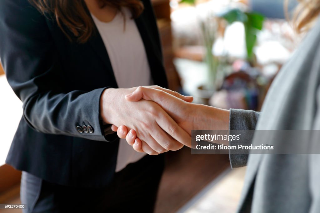 Two business women shaking hands