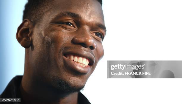 France's midfielder Paul Pogba smiles during a press conference in Clairefontaine en Yvelines on June 5, 2017 as part of the team preparation for the...