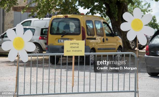 Homemade sunflowers made of cardboard and paper plates together with a no parking sign on June 5, 2017 in Saussignac, France. Monday is a public...