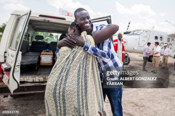 Emmanuel Samuel, 17 years old, hugs his mother, Georgina Pagan as he reunites with her after landing in Aburoc, South Sudan, on June 5, 2017....
