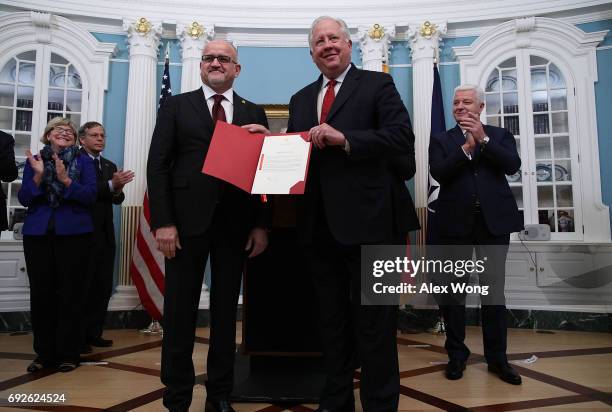 Montenegro Foreign Minister Srdjan Darmanovic presents a document to U.S. Undersecretary of State for Political Affairs Thomas Shannon as Montenegro...