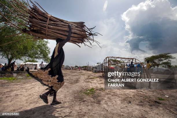 Displaced woman carries wood to build a new shelter in Aburoc, South Sudan on June 5, 2017. Government offensives on the West Bank of the Nile river...