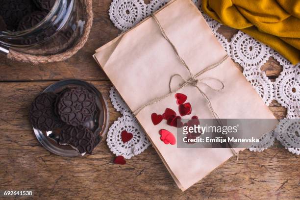 wrapped empty old paper and cocoa cookies on wooden table - love letter stock pictures, royalty-free photos & images