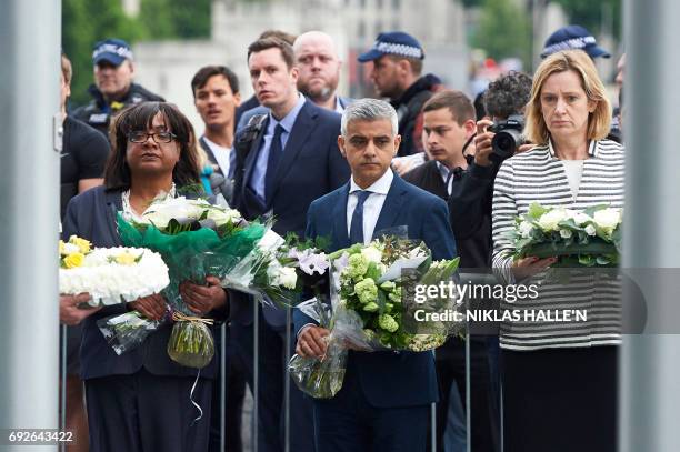 London Mayor Sadiq Khan , Home Secretary Amber Rudd and Shadow Home Secretary Diane Abbott hold flowers at Potters Fields Park in London on June 5...