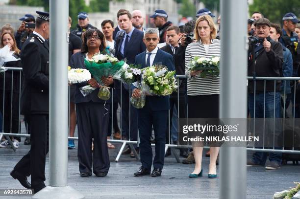 London Mayor Sadiq Khan , Home Secretary Amber Rudd and Shadow Home Secretary Diane Abbott hold flowers at Potters Fields Park in London on June 5...