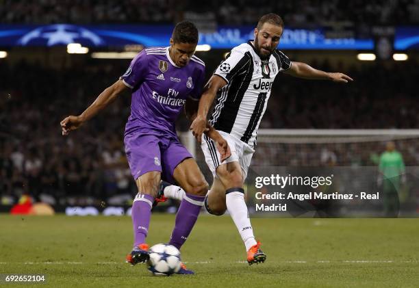 Raphael Varane of Real Madrid competes for the ball with Gonzalo Higuain of Juventus during the UEFA Champions League Final match between Juventus...