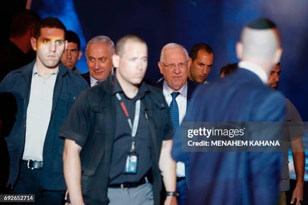Israeli Prime Minister Benjamin Netanyahu and President Reuven Rivlin walk surrounded by their personal security detail during a ceremony marking the...