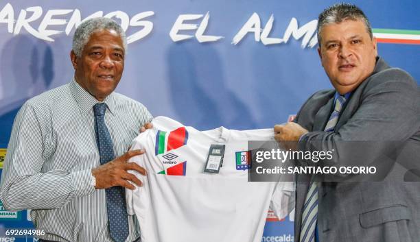 Francisco Maturana, the new coach of the Once Caldas football team, and the team's president Tulio Mario Castrillon hold up an Once Caldas jersey...