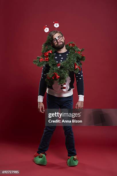 man wearing christmas clothes and a garland. debica, poland.  - kitsch stock-fotos und bilder