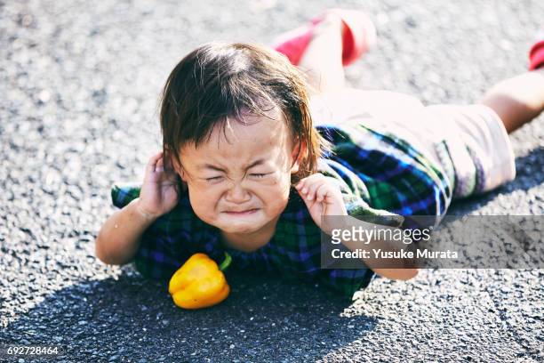 little girl falling down and crying on the road - toddler crying stock pictures, royalty-free photos & images