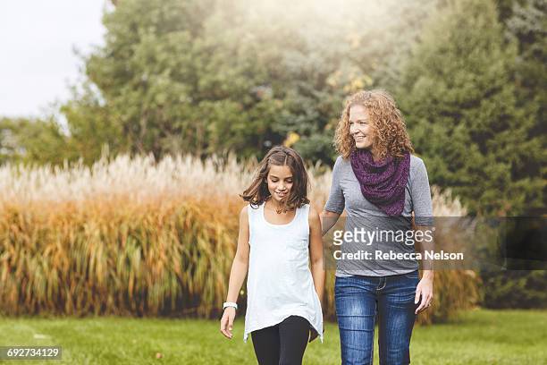 aunt and niece walking together in garden - sobrina fotografías e imágenes de stock