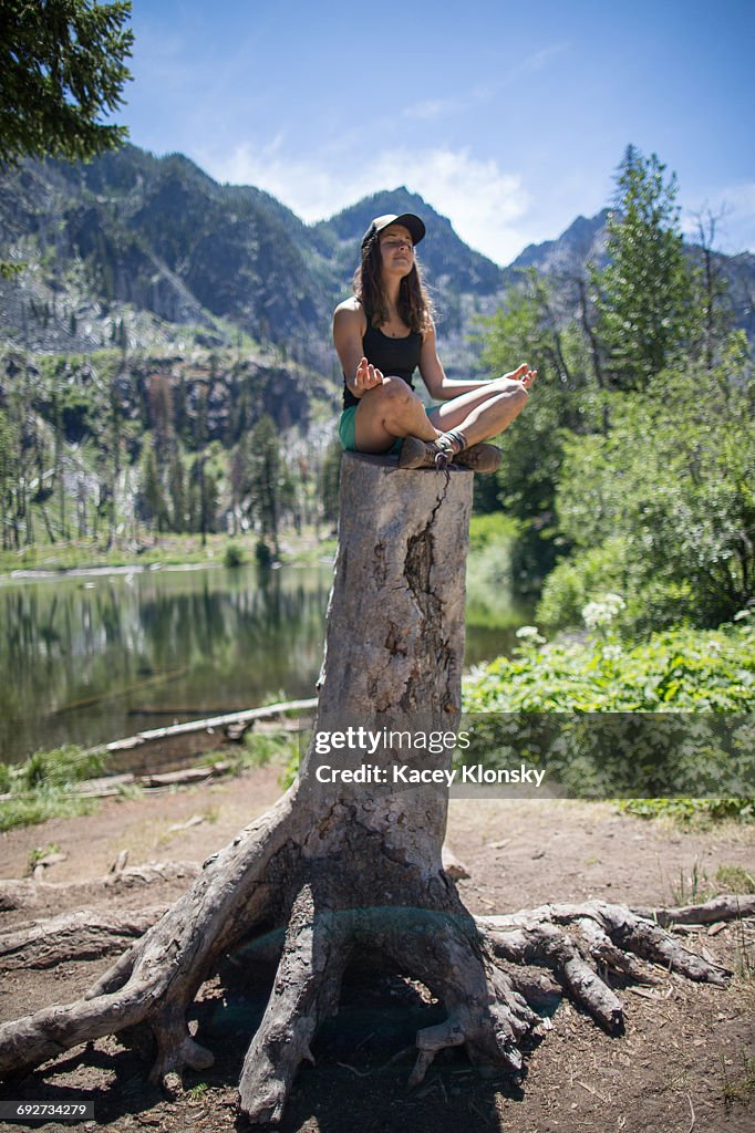 Hiker practising yoga on tree stump, Enchantments, Alpine Lakes Wilderness, Washington, USA