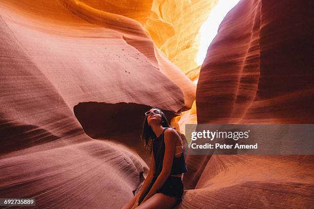 woman looking up at sunlight in cave, antelope canyon, page, arizona, usa - with canon stock-fotos und bilder