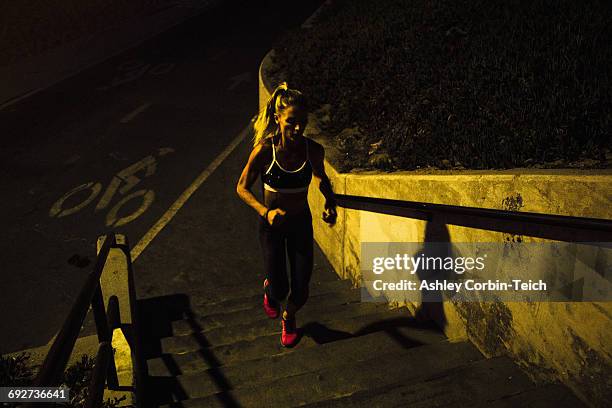 woman jogging up steps at night - ashley cooper - fotografias e filmes do acervo