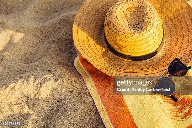 sunglasses, straw hat and beach towel on sand - strandfilt bildbanksfoton och bilder