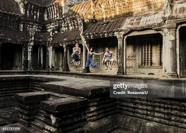 friends jumping in mid air, angkor wat temple, siem reap, cambodia - angkor wat stock pictures, royalty-free photos & images