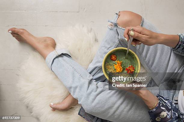 overhead view of woman holding bowl of food garnished with flowers - soup home foto e immagini stock