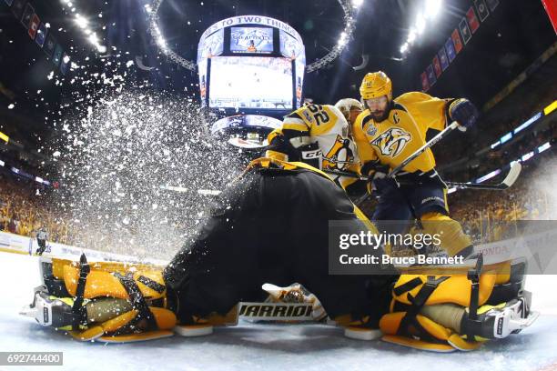 Mike Fisher of the Nashville Predators crashes the net as Carl Hagelin defends and Matt Murray of the Pittsburgh Penguins tends to net during the...