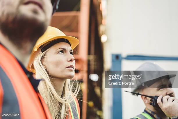 young female port worker looking up at shipyard - longshoremen 個照片及圖片檔