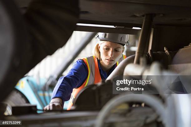 female port worker examining machinery in shipyard - dock worker stockfoto's en -beelden