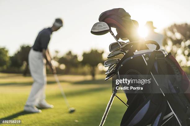 close-up of golf bag with people in background - bolsa de golf fotografías e imágenes de stock