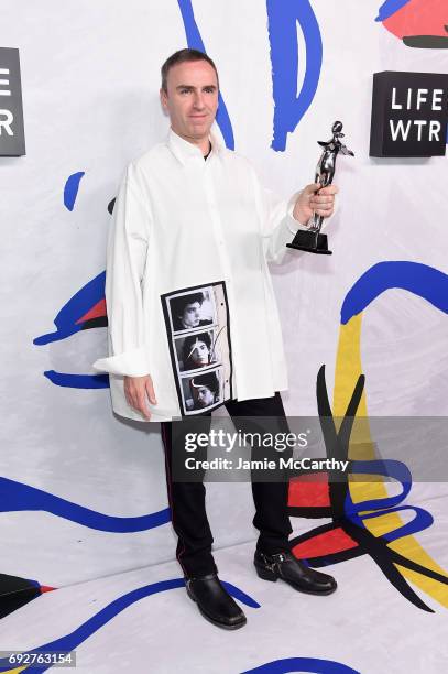 Designer Raf Simons for Calvin Klein poses with Womenswear Designer of the Year award on the Winners Walk during 2017 CFDA Fashion Awards at...