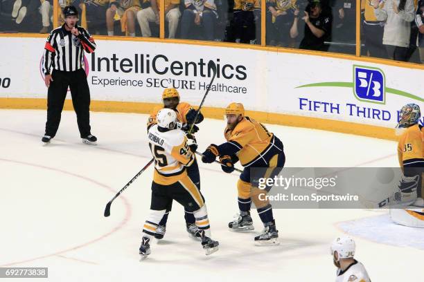 Referee Kevin Pollock looks on as Nashville Predators defenseman Mattias Ekholm and Pittsburgh Penguins right wing Josh Archibald battle for position...