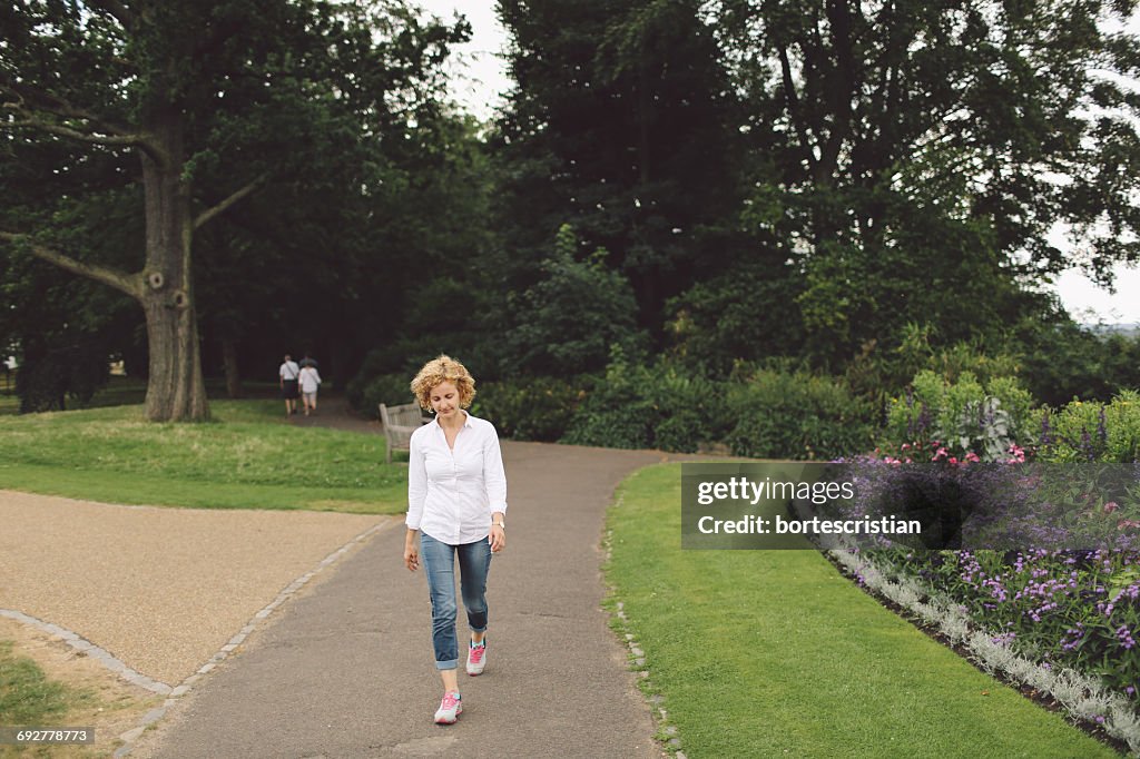 Full Length Of Woman Walking On Footpath In Park