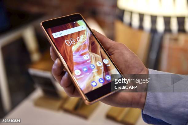Man holds the Nokia smartphone model 6 during a press conference of Finnish mobile phone maker HMD Global in Helsinki, on June 6, 2017. / AFP PHOTO /...
