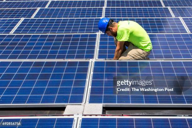 June 2, 2017: CREDIT: Mike Catanzaro, panel installer at Accelerate Solar, finishes installed electrical wiring at a solar array he recently...