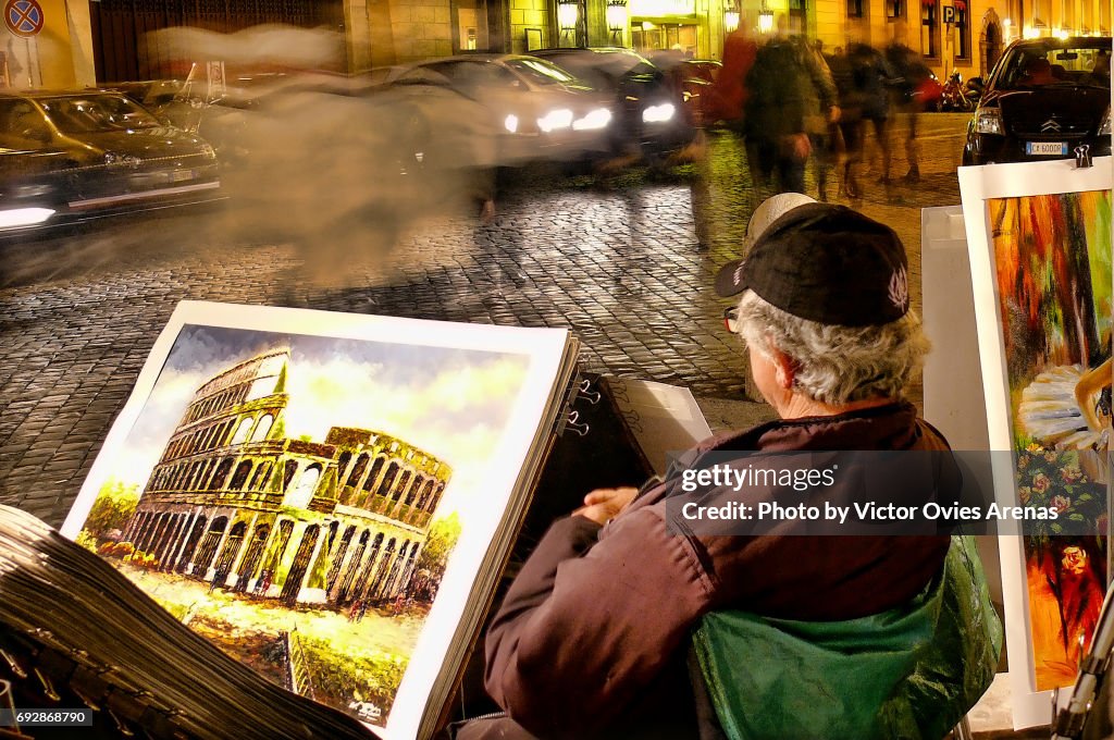 Local artist selling paintings at night in Rome, Italy