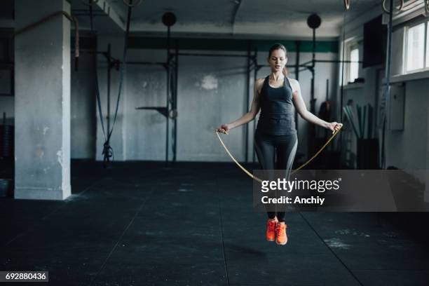 attractive young woman uses jumping rope to train - skipping along stock pictures, royalty-free photos & images