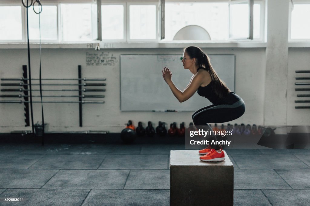 Beautiful woman doing box squats at the gym