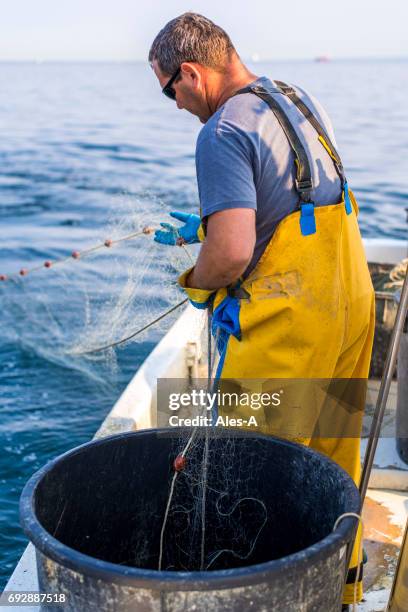 pêcheur sur son bateau - fisherman stock photos et images de collection