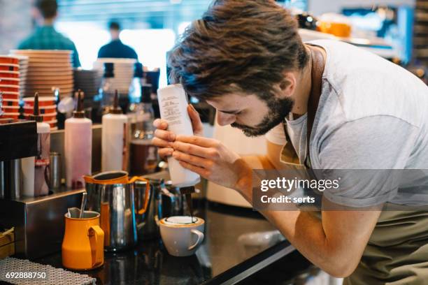 young barista pouring latte art with chocolate sauce - caramel stock pictures, royalty-free photos & images