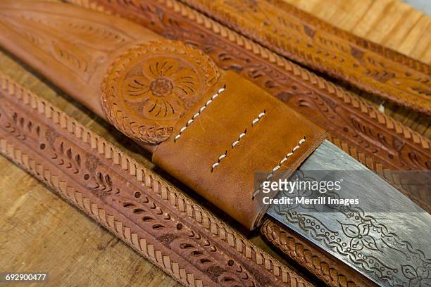 hand-tooled leather belt with knife holder - ceinture par dessus photos et images de collection