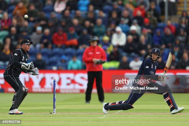 Joe Root of England reverse sweeps a delivery as wicketkeeper Luke Ronchi looks on during the ICC Champions Trophy match between England and New...